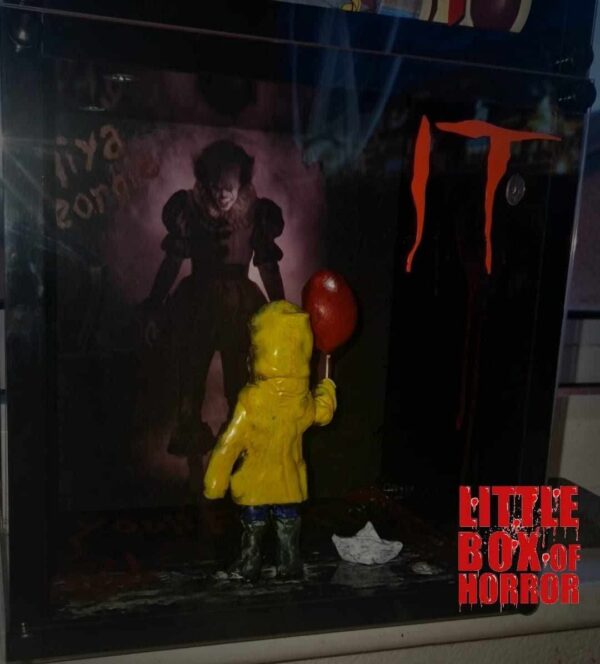 IT PENNYWISE WITH GEORGIE HOLDING BALOON